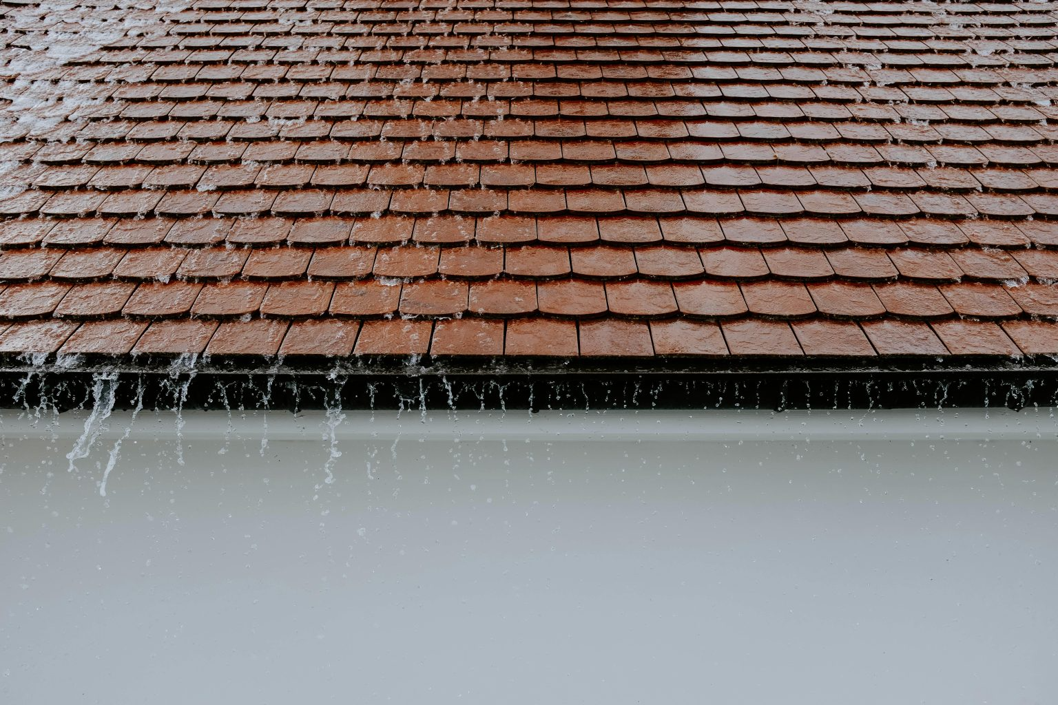 water falling from roof and overspilling over the gutters