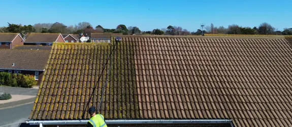 one of our skilled technicians carrying out professional roof cleaning in Gloucester